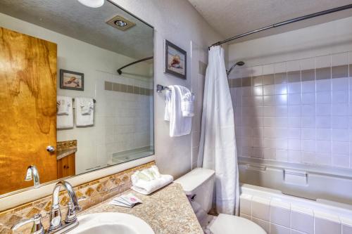 a bathroom with a sink and a toilet and a mirror at Beaches Inn | Pelicans View Cottage in Cannon Beach