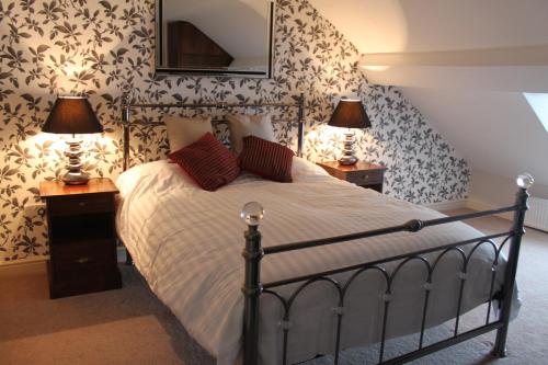 a bedroom with a bed with two night stands and two lamps at Priory hotel in Cartmel