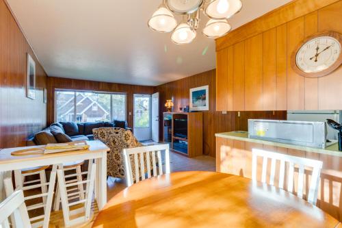 a kitchen and living room with a table and a clock at 8th Hole Getaway Condo MCA #1209 in Manzanita