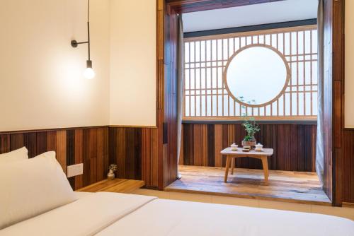 a bedroom with a bed and a table with a mirror at Zen Tea House Seven Stars Park in Guilin