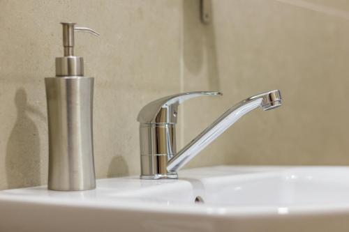 a bathroom sink with a silver faucet at Agropensiunea Mara in Mărişel