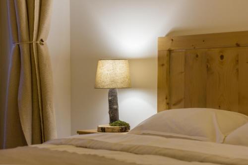 a lamp on a table next to a bed at Agropensiunea Mara in Mărişel