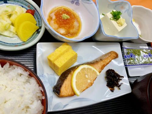 a plate of food with rice and a slice of lemon at Hotel Monteroza Ohta in Ota