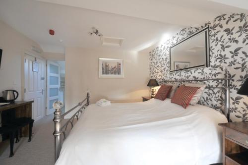 a bedroom with a large white bed in a room at Priory hotel in Cartmel