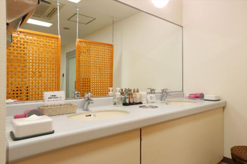 a bathroom with two sinks and a large mirror at Hotel Hokke Club Sapporo in Sapporo