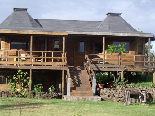 a large wooden house with a porch and stairs at Cabañas Tokerau in Hanga Roa