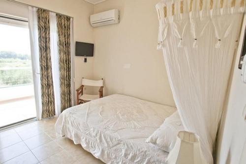 a white bed in a room with a window at TEO-VILLA-1, private pool, sea and golf in Afantou