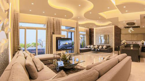 a living room with a large couch and a television at Exquisite Palm Villa with Private Beach, Palma Residences in Dubai
