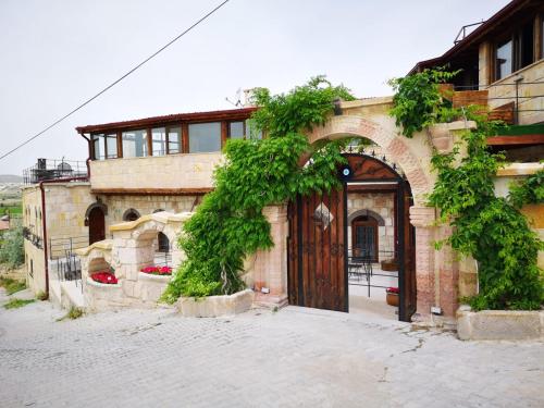 a building with a large wooden door with vines at Prime Cappadocia Suites in Nevsehir