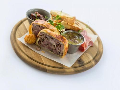 a plate of food with a sandwich and some dips at The Village Hotel, Bar and Restaurant in Bettystown