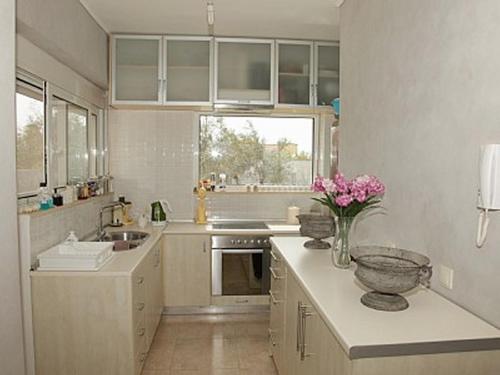 a kitchen with a vase of flowers on a counter at TEO-VILLA-1, private pool, sea and golf in Afantou