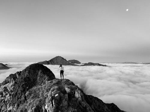 a person standing on top of a mountain above the clouds at Hotel Ratschingserhof in Racines