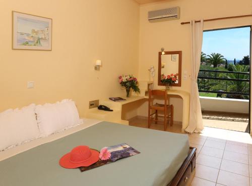 a bedroom with a bed with a hat on it at Paradise Hotel Corfu in Gouvia