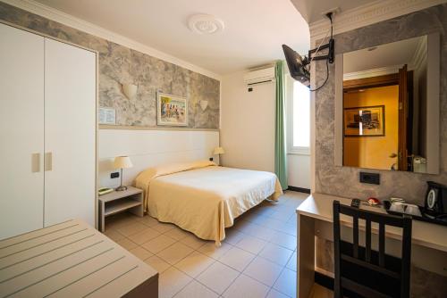 a hotel room with a bed and a mirror at Hotel Marina in Sestri Levante