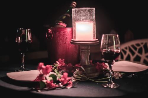 a table with a candle and two glasses of wine at Foothill Pushkar Resort in Pushkar