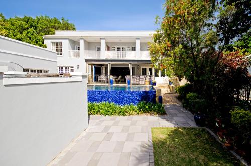 an exterior view of a house with a swimming pool at Lodge on Main Guest House and Conference Centre in Port Elizabeth