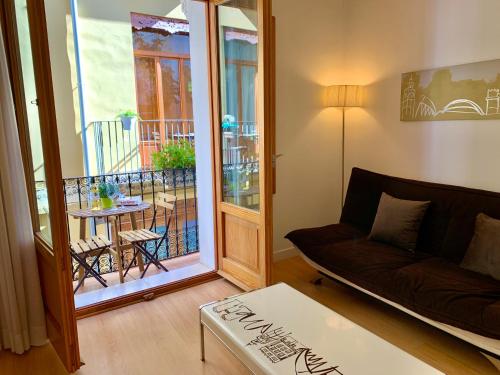 a living room with a couch and a balcony at Edificio Palomar - PalomarGroup in Valencia