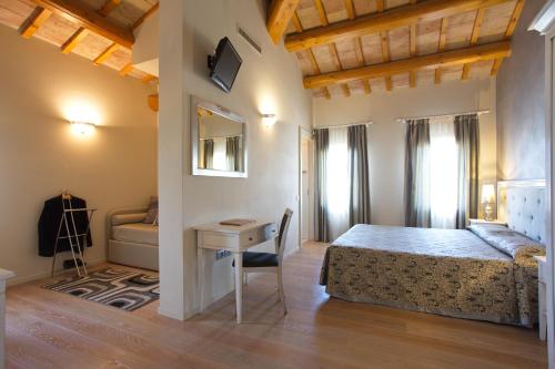 - une chambre avec un lit, un bureau et un canapé dans l'établissement Hotel Asolo, à Asolo