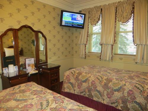 a bedroom with a television and a bed at Athabasca Hotel in Jasper
