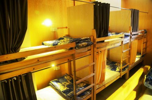a room with three bunk beds in a room at Salaam Namastey Backpackers in Mumbai