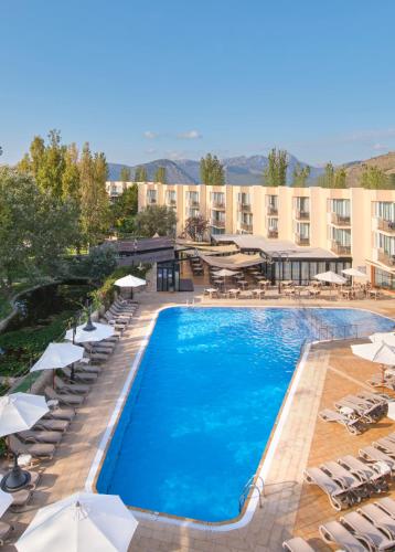 a pool at a hotel with chairs and umbrellas at Aparthotel Duva & Spa in Port de Pollensa