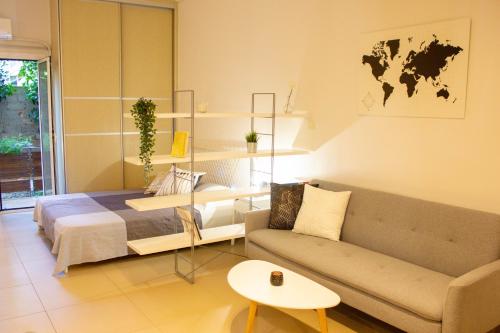 Cette chambre comprend un lit, un canapé et une table. dans l'établissement Cozy Studio in Central Glyfada, à Athènes