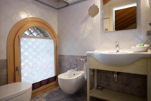 La salle de bains est pourvue d'un lavabo, de toilettes et d'un miroir. dans l'établissement Hotel Asolo, à Asolo