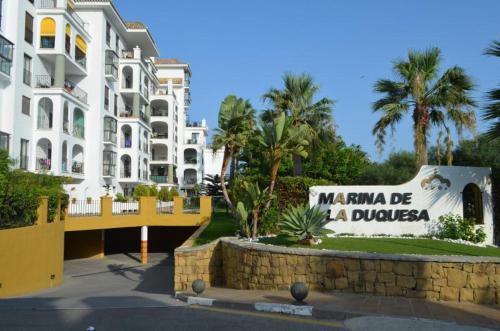una señal frente a un edificio con palmeras en PENTHOUSE Marina La Duquesa, en Manilva