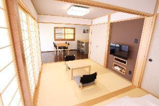 a living room with a view of a dining room at Tabinoteitaku Okinawa Nakijin HOMANN CONCEPT in Nakijin