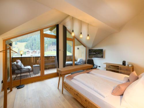 a bedroom with a bed and a large window at Hotel Bergzeit in Grossarl