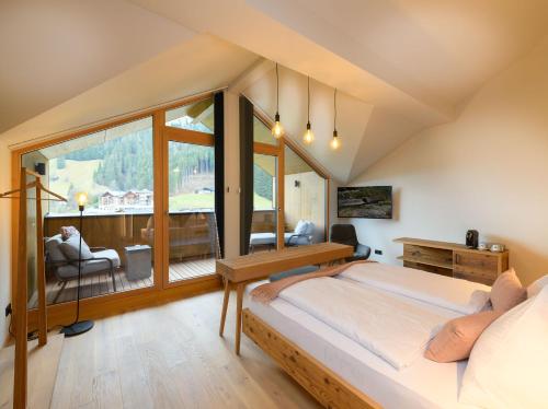 Hotel Bergzeit في غروسارل: غرفة نوم بسرير ونافذة كبيرة