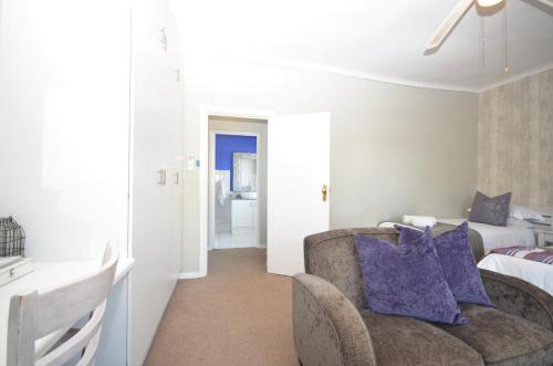 a living room with a couch and a bedroom at Lodge on Main Guest House and Conference Centre in Port Elizabeth