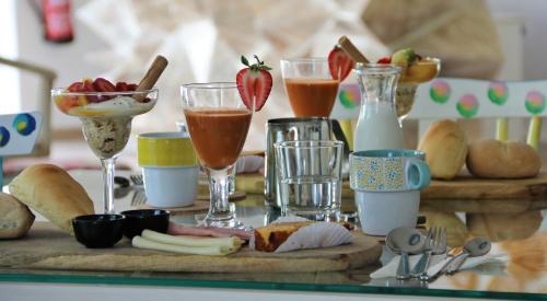 a table topped with glasses of drinks and food at Authentic Tavira Hotel in Tavira