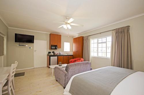 a bedroom with a bed and a couch and a table at Lodge on Main Guest House and Conference Centre in Port Elizabeth