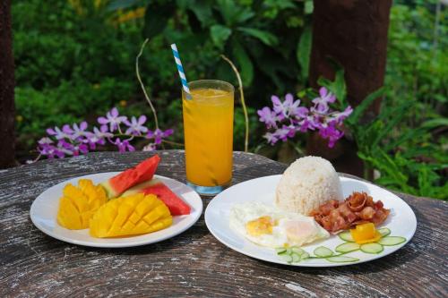 two plates of food on a table with a drink at Loboc River Resort in Loboc
