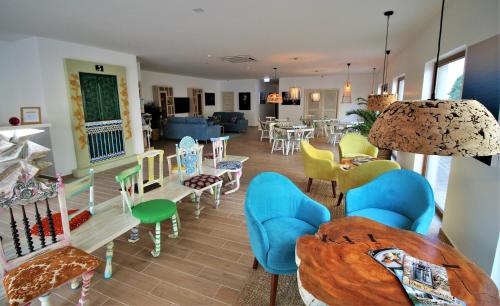 Authentic Tavira Hotel في تافيرا: غرفة معيشة مليئة بالاثاث وطاولة وكراسي