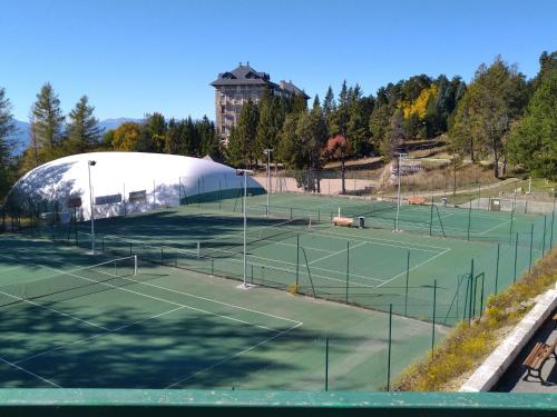 a tennis court with two tennis courts at Studio à font romeu grand hôtel in Font-Romeu-Odeillo-Via