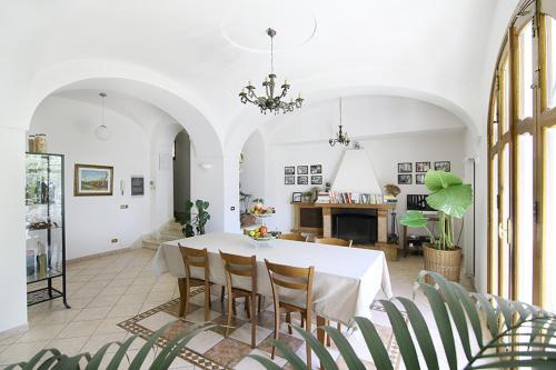 a dining room with a white table and chairs at Colle dell'Ara in Positano