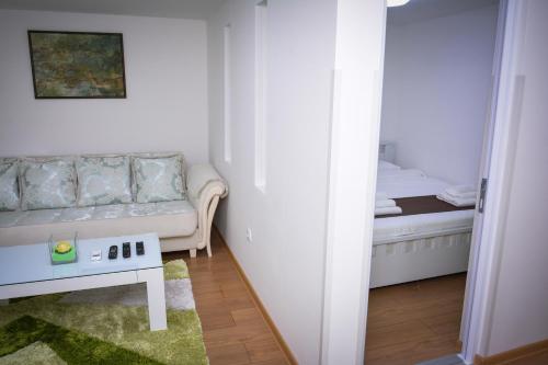 a small living room with a couch and a bed at Korzo Prenoćište in Novi Pazar