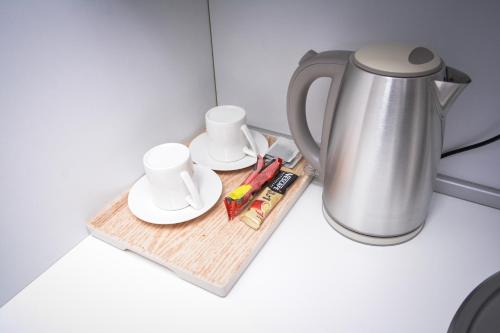 a tea kettle and cups on a wooden tray at Korzo Prenoćište in Novi Pazar