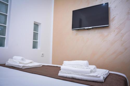 een kamer met handdoeken en een tv aan de muur bij Korzo Prenoćište in Novi Pazar