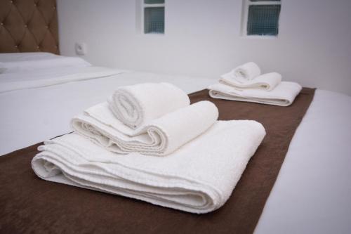 a pile of towels sitting on top of a bed at Korzo Prenoćište in Novi Pazar