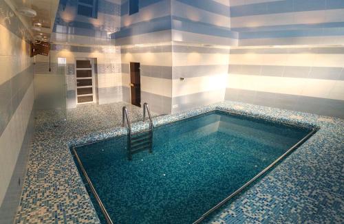 a swimming pool with a chair in a bathroom at Avalon Palace in Ternopil