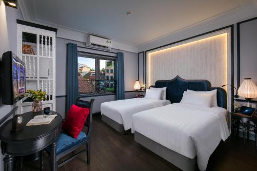 Habitación de hotel con 2 camas, escritorio y TV. en La Beaute Boutique Hotel & Spa, en Hanói