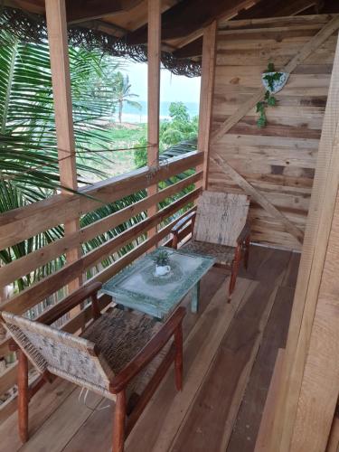 a porch with two chairs and a table on it at Memo's Beach in Nilaveli