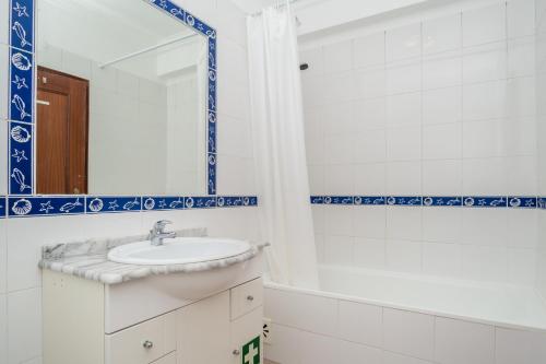 y baño con lavabo y espejo. en Apartamentos Castelos da Rocha, en Portimão