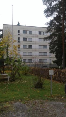 a large white building in front of a park at Varakämppä in Äänekoski