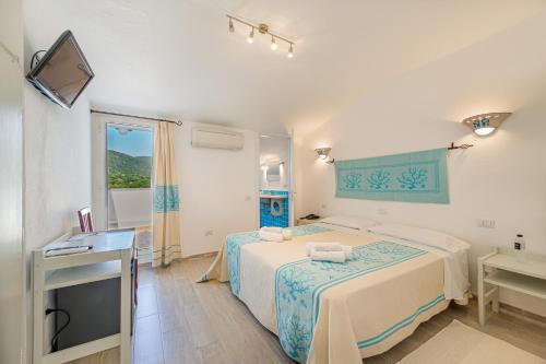 Habitación de hotel con cama y ventana en Hotel Le Mimose en San Teodoro
