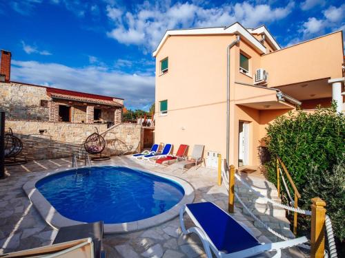 uma piscina com cadeiras e uma casa em Splendid Holiday Home in Jasenice em Maslenica