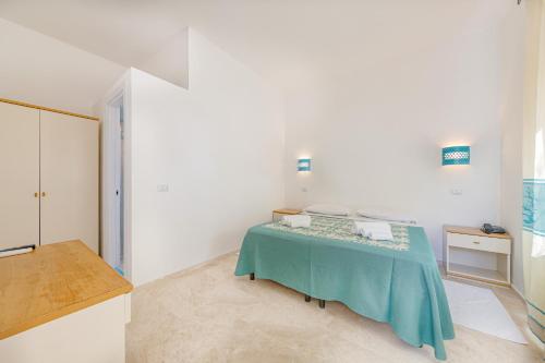 a bedroom with a bed in a white room at Hotel Le Mimose in San Teodoro